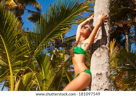 Fashion young woman looking up at summer Caribbean beach. Elegant brunette woman on travel holidays vacation outdoors.