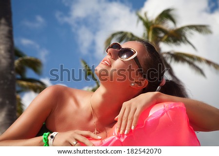 Woman happy under the palm trees. Girl enjoying sun day looking up at sky smiling cheerful.