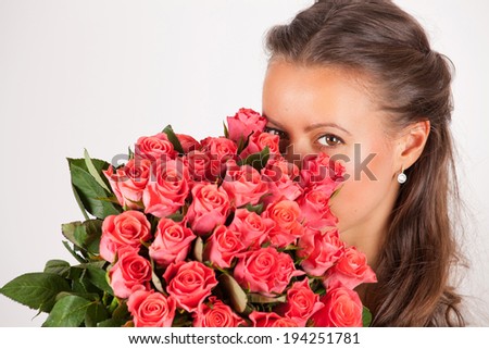 Beautiful woman with a large Bouquet of flowers in her arms. Pink roses