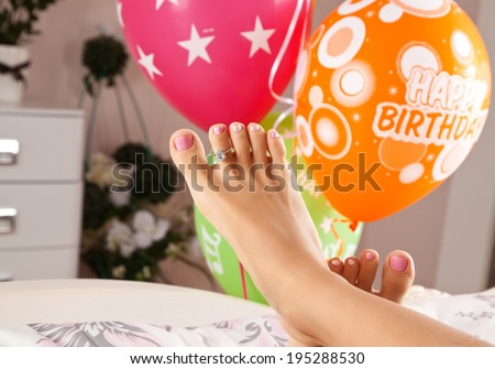 woman feet in bed with ring present on finger, birthday morning