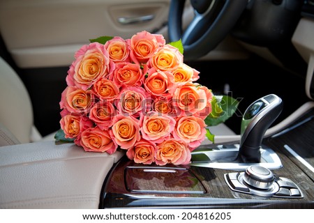 Big bouquet of colorful flower from beautiful fresh pink roses in luxury car. Valentines day romantic