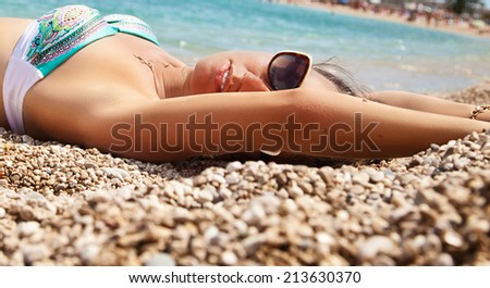 Fashion girl in beautiful bikini lying on beach. Vacations And Tourism Concept.