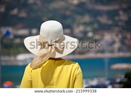 Rear view of beautiful young woman looking away. Enjoying looking view of beach sea on hot summer day in France