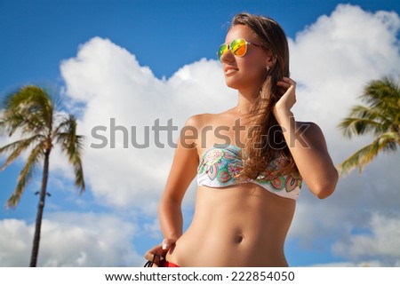 Portrait of sexy cheerful woman holding hand behind head, relaxing at the luxury resort on beach  on the hawaiian Honolulu island. Summer luxury vacation.