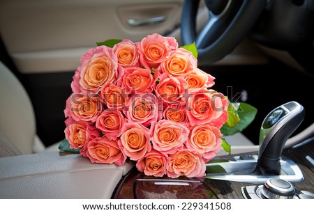 Bouquet of beautiful elegant pink roses in luxury car, express feeling. Composition for a romance or anniversary