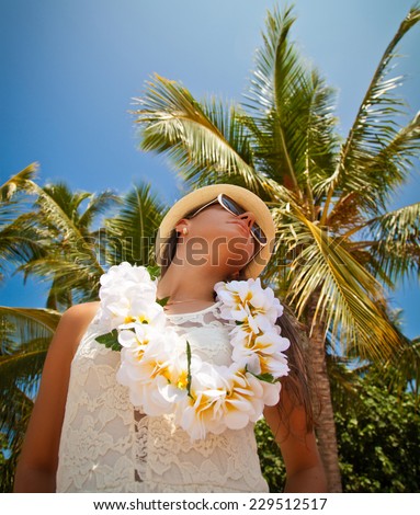 Hawaii woman with flower lei garland of white flowers. Portrait of a beautiful young woman in white dress. Welcoming Lei on the hawaiian island Honolulu.