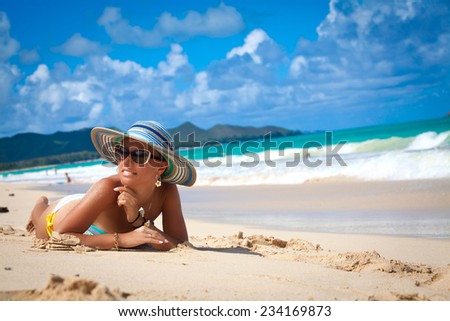 Shot of an attractive young sexy woman in a bikini relaxing at the beach. Beautiful beach holiday in Hawaii