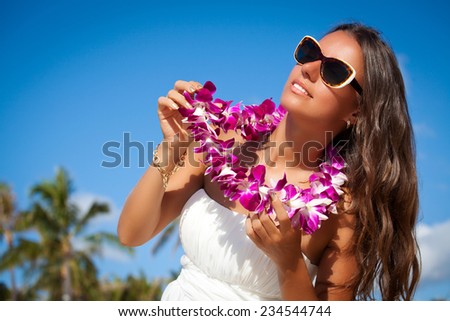 Pretty young woman with flower lei garland of pink orchids. Lei on the hawaiian island Oahu Island.