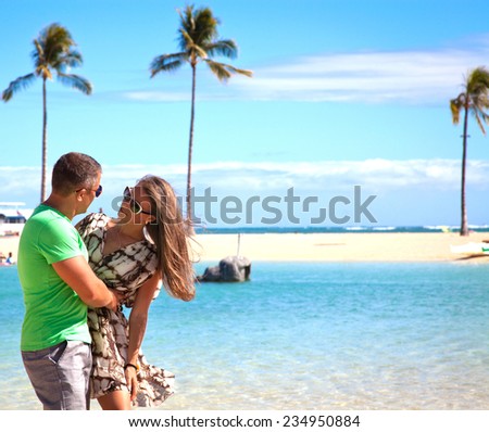 Happy couple spending romantic time together on beach. Loving couple hugging each other. Summer vacation in Hawaii.