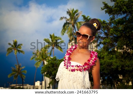 Glamorous woman in white dress enjoying the perfect sunset on tropical resort. Summer luxury vacation in Hawaii. Honolulu, HI, United States Island of Oahu