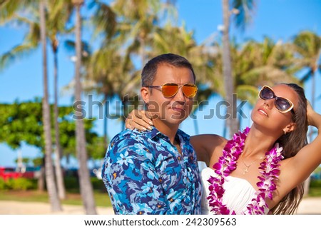 Young beautiful couple enjoying beach getaway. Couple in love, summer luxury vacation in Hawaii. Travel holidays concept.