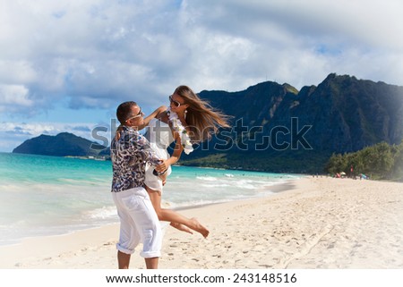 Young beautiful couple enjoying beach getaway. Couple in love, summer luxury vacation in Hawaii. Travel holidays concept.