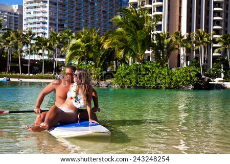 romantic honeymoon couple swimming in surfboard, tropical summer holiday vacation in Hawaii. Carefree stress free lifestyle concept.