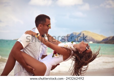 Affectionate young couple on a calm and tranquil beach. Feeling the warmth of his touch. Couple in love, summer luxury vacation in Hawaii. Travel holidays concept.