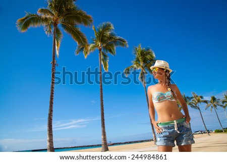 Beach woman with sunglasses and straw hat happy and free on Waikiki, Oahu, Hawaii, USA. Pretty brunette on travel vacation holidays having good time on Hawaiian Waikiki beach.