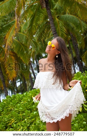 Free woman in white dress feeling happy on the Hawaiian beach. Holiday resort vacation. Hawaii, United States Island of Oahu