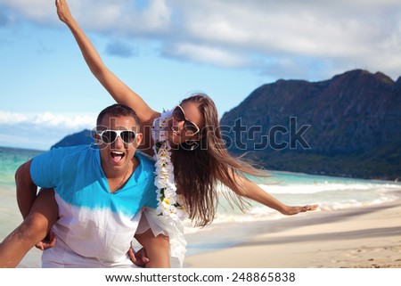 Affectionate young couple on a calm and tranquil beach.  Couple in love, summer luxury vacation in Hawaii. Travel holidays concept.