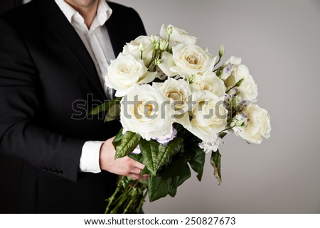 well-dressed man holding a bouquet of flowers. Holidays and celebrations. Valentines day.