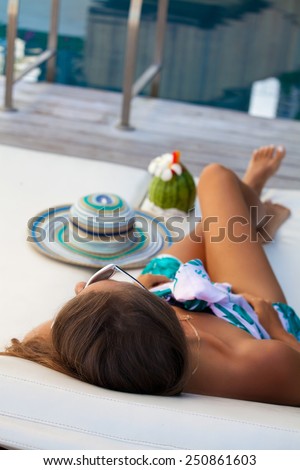 Sexy cheerful woman relaxing at the luxury poolside. Girl at travel spa resort pool in Hawaii island. Summer luxury vacation. (focus on woman head)