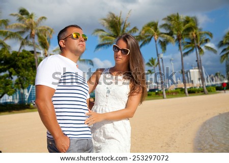 Happy couple spending romantic time together on beach. Loving couple hugging each other. Summer luxury vacation in Hawaii.