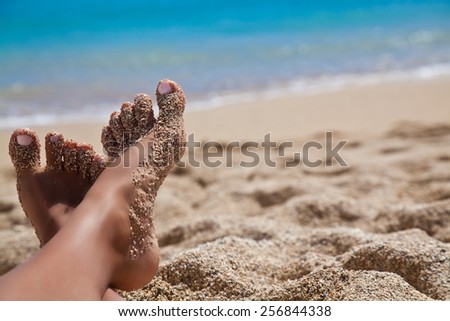 Beach travel - beautiful woman legs on sand beach in Hawaii. Travel concept. Vacation