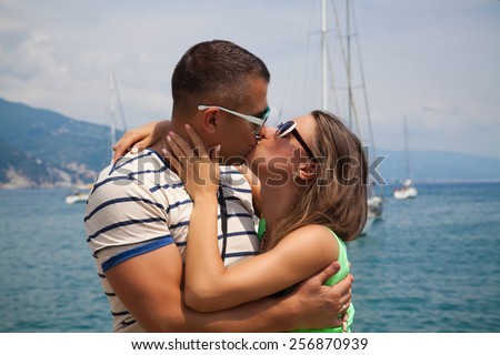 Happy young lovers enjoying summer vacation holiday. Couple hugging and kissing each other outdoors, Italy, Portofino. Travel, romantic holidays concept.
