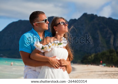 Young beautiful couple enjoying beach getaway. Couple in love, summer luxury vacation in Hawaii, USA. Travel holidays concept.