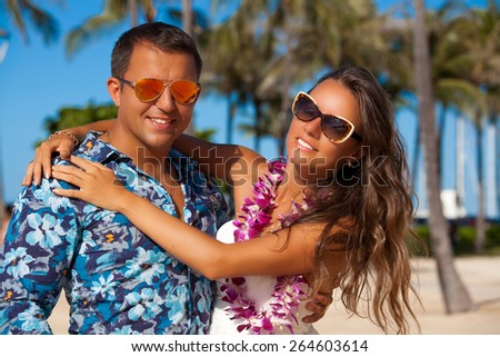 Young couple in love feeling happy on the Hawaiian beach, Oahu, Hawaii, USA. Vacations And Tourism Concept. Summer luxury vacation in Hawaii.