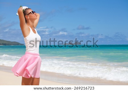 Free happy woman holding hand behind head, relaxing at the luxury resort, enjoying breathing freely fresh air. Summer luxury vacation. Hawaiian Island of Oahu
