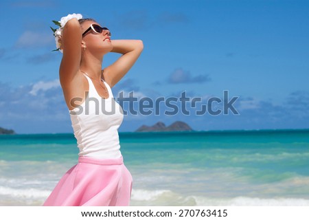 Beautiful woman holding hand behind head, relaxing at the luxury resort, enjoying breathing freely fresh air. Summer luxury vacation. Hawaiian Island of Oahu