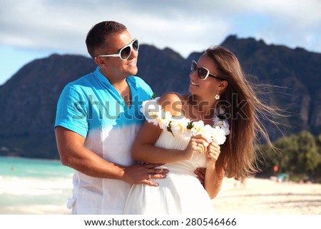 Happy Hawaii vacation couple relaxing together enjoying their holidays in perfect getaway in sunny tropical destination. Couple in love, summer luxury vacation in Hawaii. Living, loving and laughing