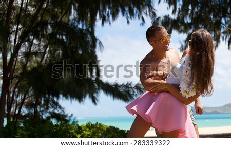 Young couple in love feeling happy on Waimanalo Beach Park, Oahu, Hawaii, USA. Vacations And Tourism Concept. Summer luxury vacation in Hawaii.