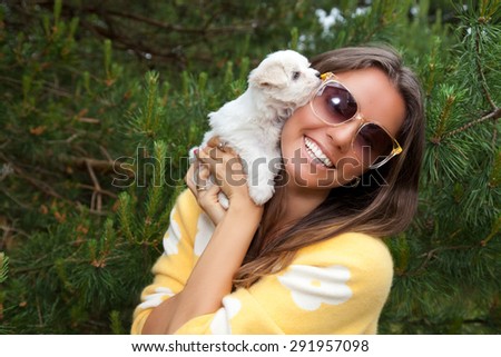 Attractive young female outside with her puppy. Cute puppy licking its attractive young female owner\'s face.