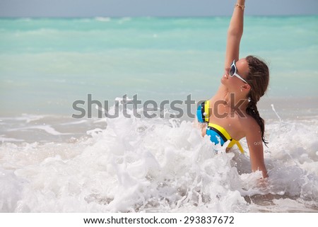 Young woman having fun in water, sea waves. Vacations And Tourism Concept.