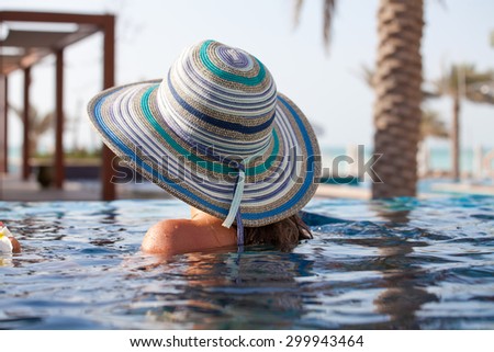 Woman relaxing at the luxury poolside. Girl at travel spa resort pool. Summer luxury vacation.
