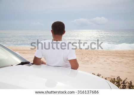 Man relaxing and daydreaming near car. Vacations And Tourism Concept. Tropical Resort.