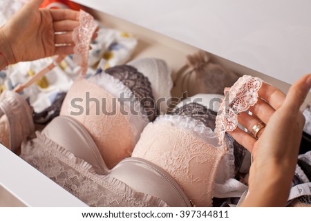 Woman choosing lingerie. Drawers filled with sexy lace lingerie. Textile, Underwear. (soft focus)