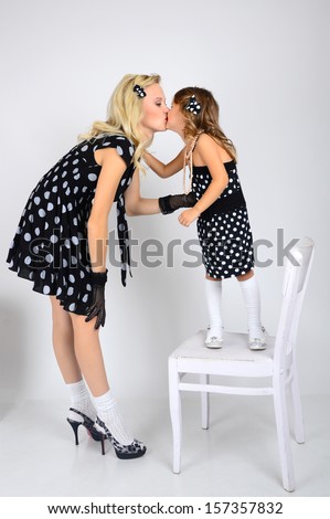 Mom and daughter polka dot black and white dresses back to back kissing