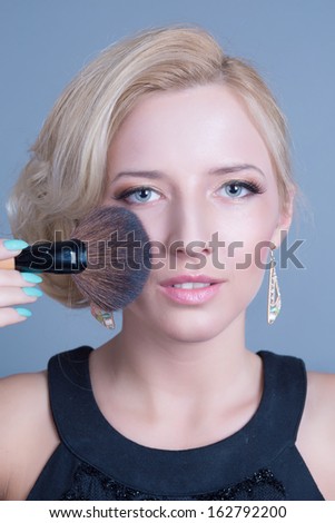 High fashion look glamour sexy woman makeup artist applying bright makeup  brush near face in studio