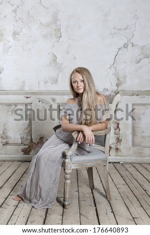 Young woman sitting on  chair  in abandoned building