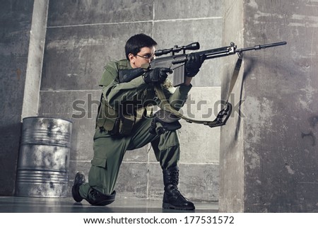Soldier aiming the target with gun in building
