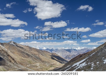 Winding mountain road among snow capped summits