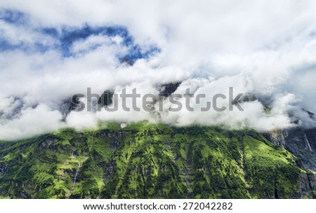 Lush green rocky mountain walls with trees and waterfalls