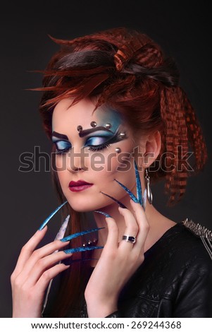 Gothic style shot of a woman with claw rings with eyes closed
