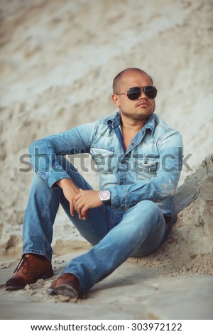 adult man lying in jeans clothes in the sand in Thailand