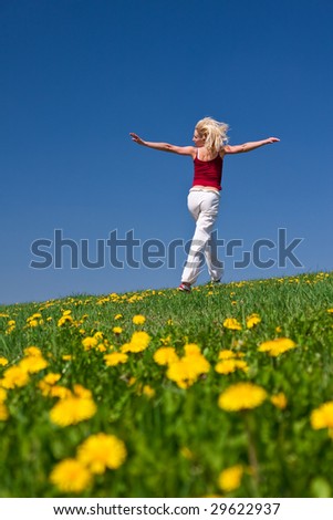 young woman having fun on a flowery meadow