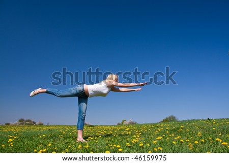female practising yoga on a flowery meadow