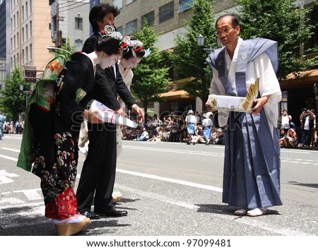 KYOTO - JULY 17: Two geishas bow to thank a participant of the famous annual Gion Festival held on July 17 2010 in Kyoto, Japan. Geishas often participate on traditional celebrations.