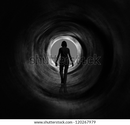 Woman is walking towards radiating light circle. it May symbolise escape, looking for exit or freedom and even death or clinical death. Black and white psychedelic vision.