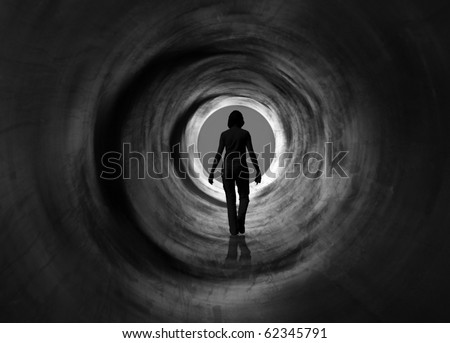 Woman is walking towards radiating light circle. it May symbolise escape, looking for exit or freedom and even death or clinical death. Black and white psychedelic vision.